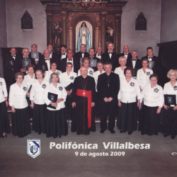 2009: A Polifónica de Vilalba con Don Uxío, Director; e os vilalbeses Monseñor Alfonso Carrasco Rouco, Bispo de Lugo, e o Cardenal Antonio María Rouco Varela. Don Uxío, coma sempre, en segundo plano.